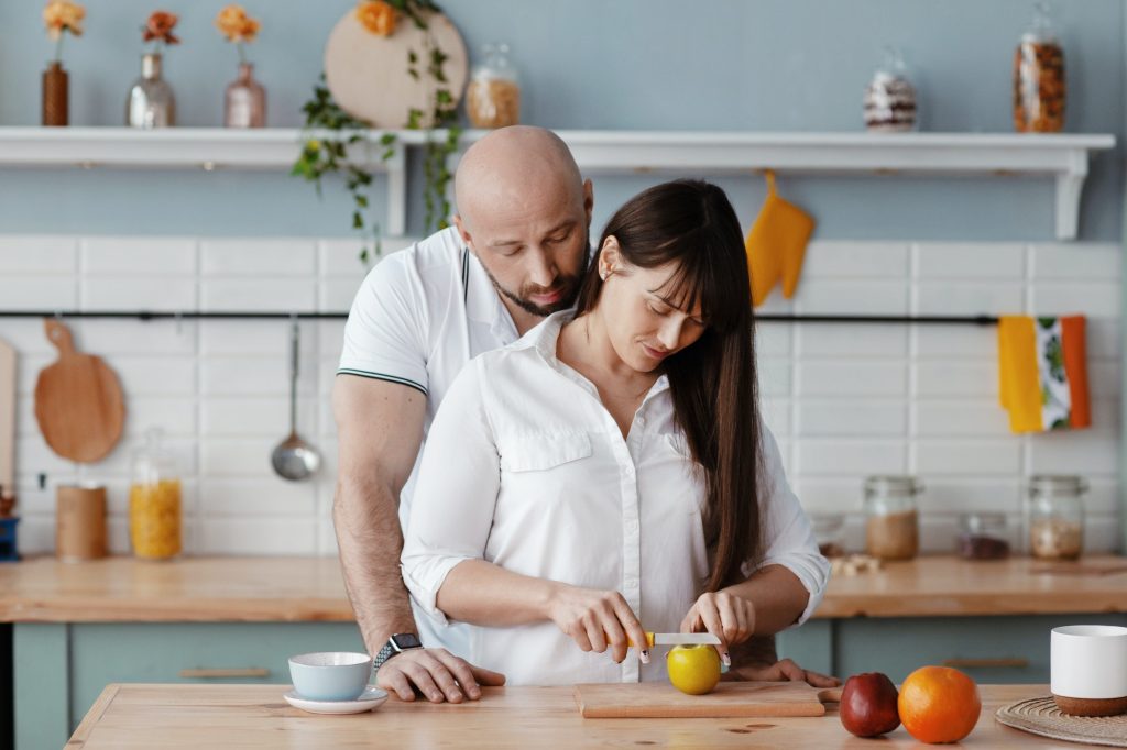 A young beautiful couple prepares Breakfast together in the kitchen on a weekend morning